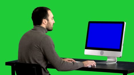 hombre de negocios trabajando con una computadora en una pantalla verde, clave de croma. pantalla azul muestra de maqueta