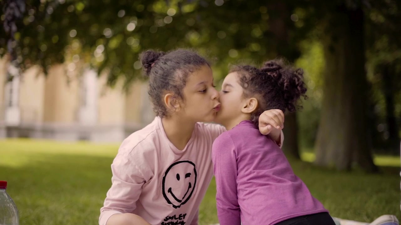 Giovani ragazze che si baciano e si salutano nel parco, picnic in un campo di campagna.