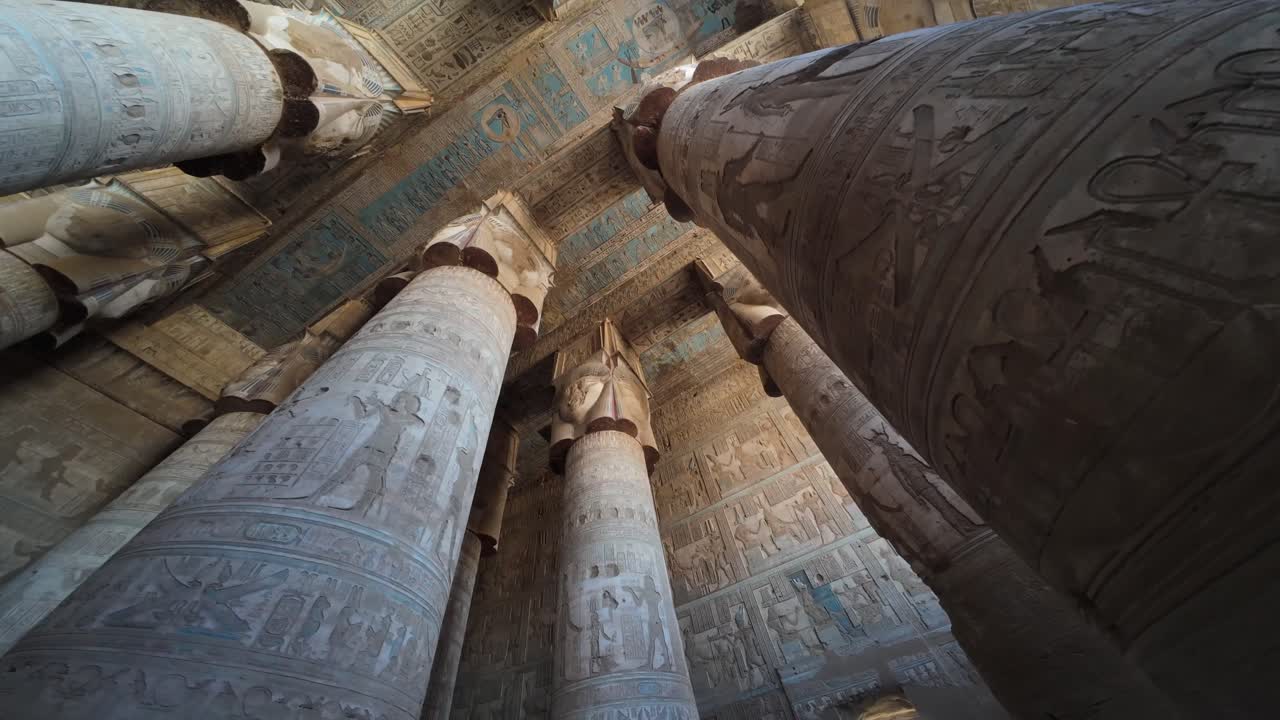 Ancient temple ceiling and pillars adorned with blue and red artwork and carvings