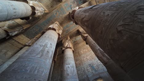 ancient temple ceiling and pillars adorned with blue and red artwork and carvings