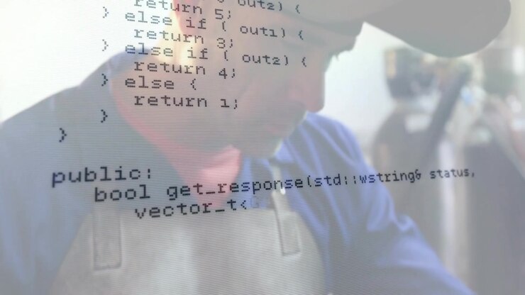 Tekniker med handske ved kode-panel inde i laboratorium, projicerer animeret C-kode grafik.