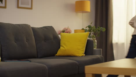 young boy sitting on sofa at home fed up with playing games or streaming putting down digital tablet