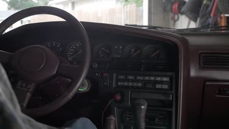 un hombre se sube a un automóvil y enciende el encendido haciendo que todas las luces del tablero se enciendan