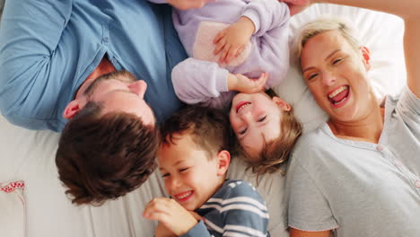 eltern, kinder und spielen auf dem bett in top-view