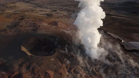 aerial at powerful geyser gunnuhver with white steam and golden sunshine