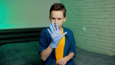boy puts on rubber gloves. stop coronavirus. pandemic. covid-19