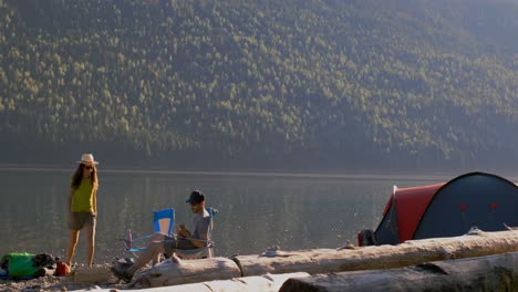 pareja acampando cerca del río 4k