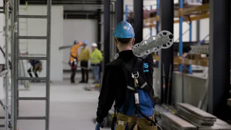 construction worker transporting a metal tube