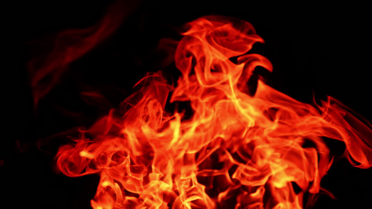 Dangerous fire with hot flames going up. Campfire at dark night. Close up.