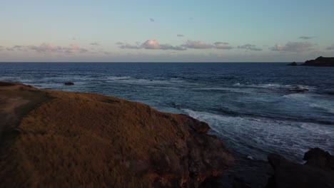 Flying-over-Island-inlet-of-rock-and-incoming-tide