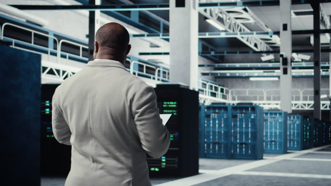 Vertical video Employee walking in server farm, analyzing equipment metrics on device screen