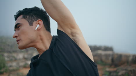 attractive man doing exercises at seaside cliff closeup. handsome brunette look