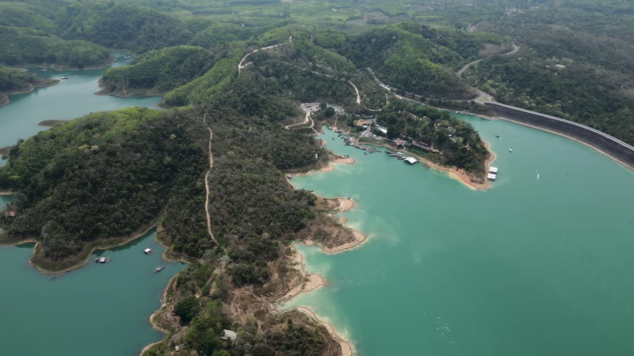Aerial View of a Serene Reservoir Surrounded by Green Hills and a Dam