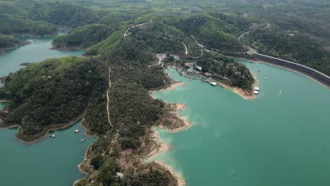 aerial view of a serene reservoir surrounded by green hills and a dam