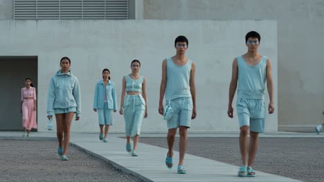 a stylish showcase: models in mint green attire walk down the runway, displaying modern fashion trends in a contemporary setting