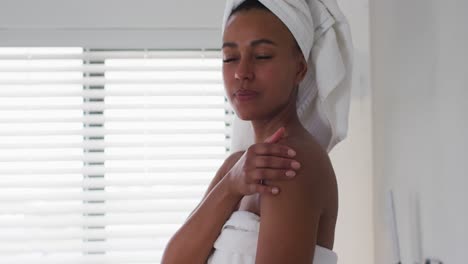 Portrait-of-african-american-woman-touching-her-skin-in-the-bathroom