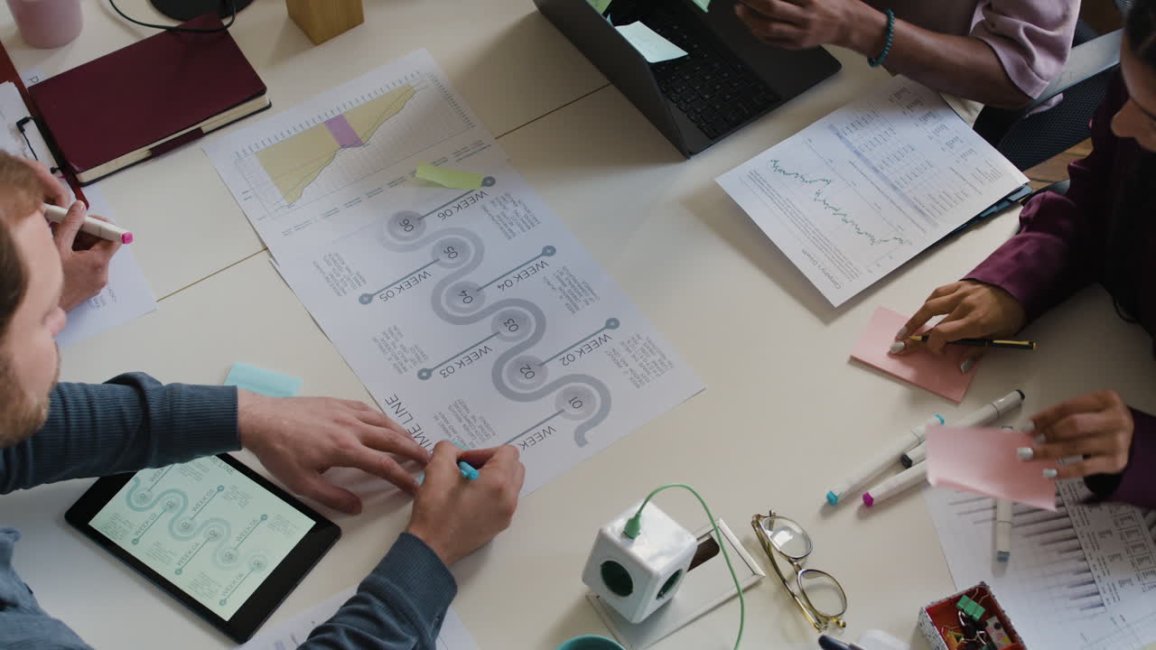 Overhead View of Team Collaborating on Project Planning at a Business Meeting