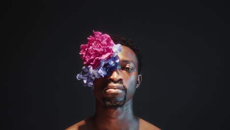 portrait of young african american man with flower eyepatch