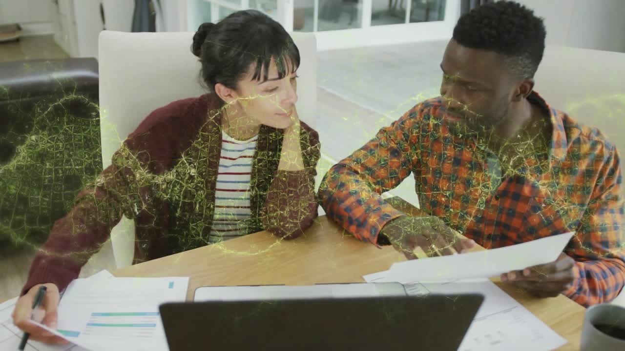 Woman holding pen above charts, network graphic appearing as couple analyzing finances on laptop