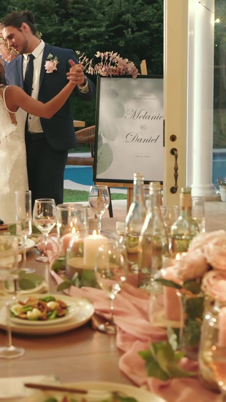 Video verticale: Sposi che salutano gli invitati a tavola mentre un invitato barbuto applaude e si dirige verso il patio