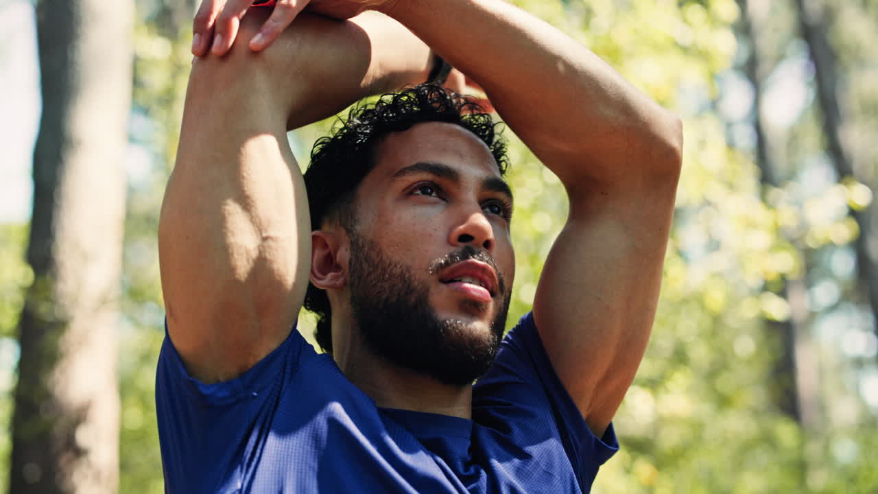 Athlete Stretching Arms Above Head in Green Forest