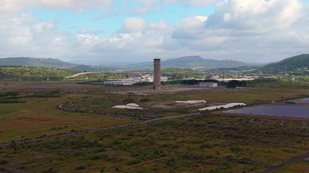 Centrale elettrica a gas dismessa dopo demolizione controllata con una sola torre rimasta a Port Talbot, Regno Unito. Ottimo per documentari ambientali, servizi sulla transizione energetica, storia industriale.
