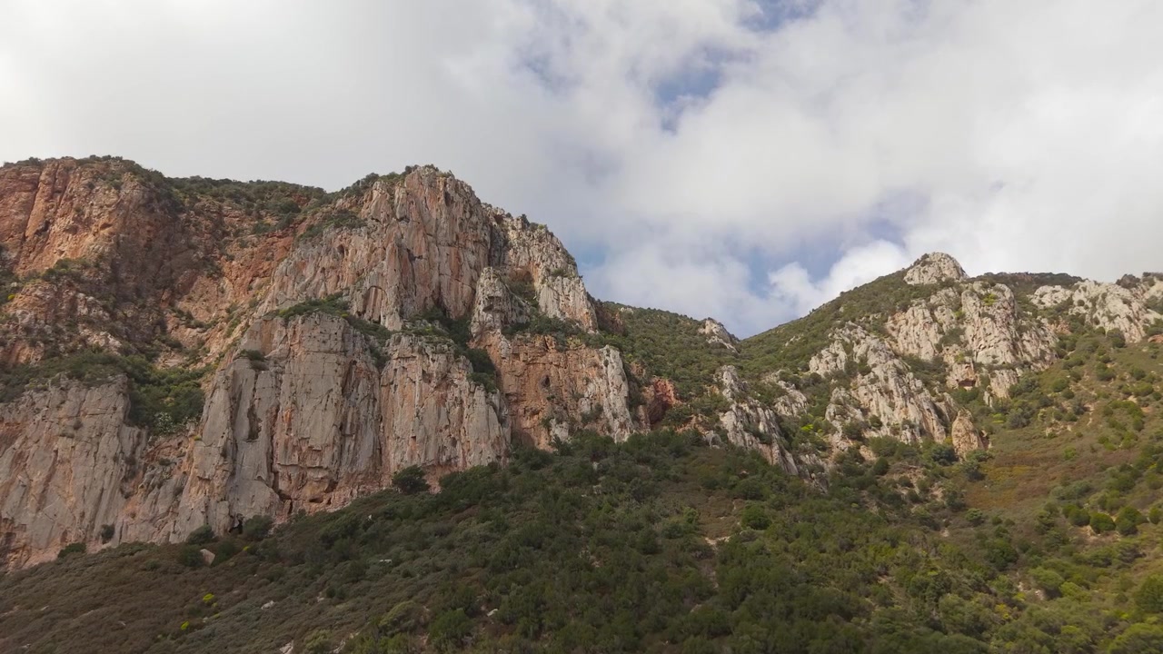 Imponenti scogliere calcaree si ergono lungo la costa sud-occidentale vicino a Porto Flavia a Masua, Sardegna, Italia. Ripresa aerea