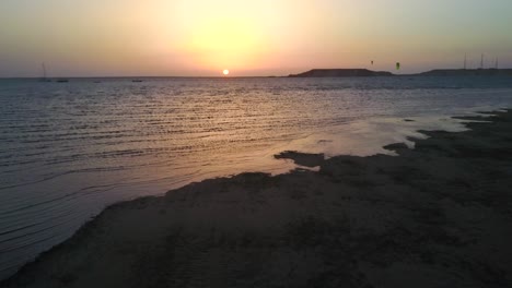 Drone-footage-zooming-into-the-sunset-over-the-lagoon-in-Dakhla,-Morocco