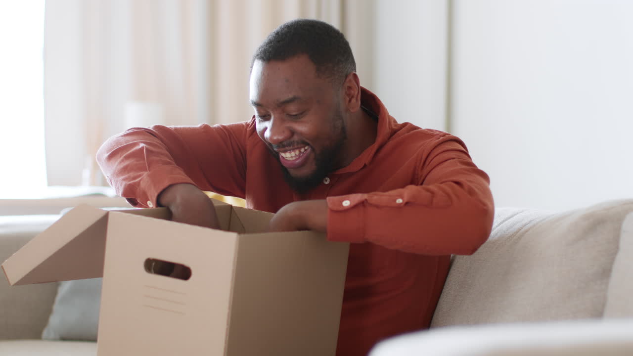 Man Opening Cardboard Box on a Couch
