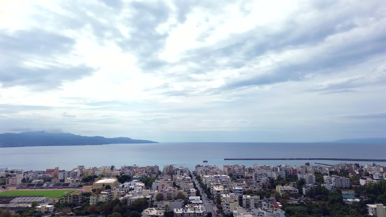 Aerial high angle view of Messinian gulf, cityscape of Kalamata on the foreground , bright cloudy sky on an autumn day , left pan drone movement 4k