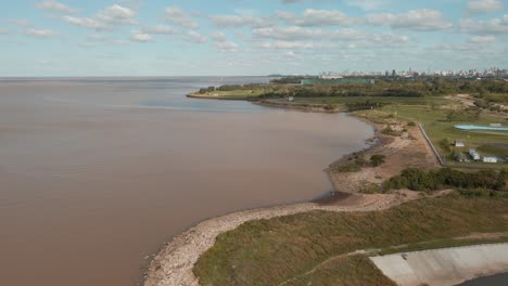 Luftaufnahme-Der-Küste-Des-Flusses-La-Plata-Tagsüber,-Die-Stadt-Buenos-Aires-Im-Hintergrund-Enthüllt