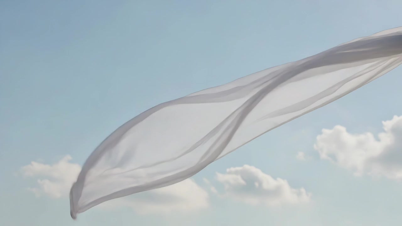 Tessuto bianco trasparente che ondeggia, si gonfia e si attorciglia attraverso un cielo azzurro pallido mentre la mano di chi lo tiene tira.