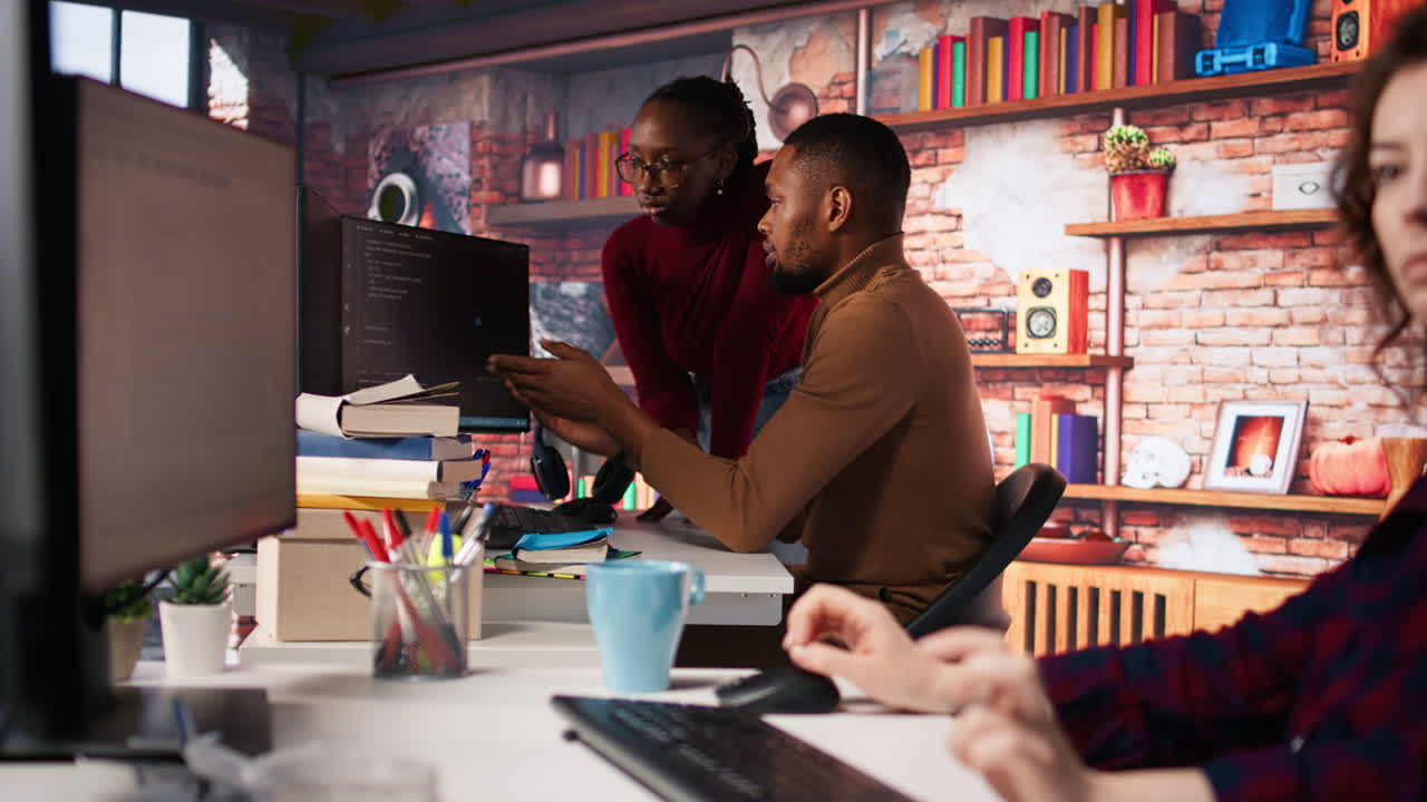 un equipo de trabajadores de una startup realizando una revisión de código en la pc para arreglar errores