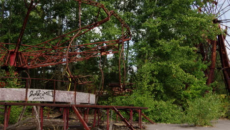 abandoned swing ride spinning on windy day in pripyat, zoom out view