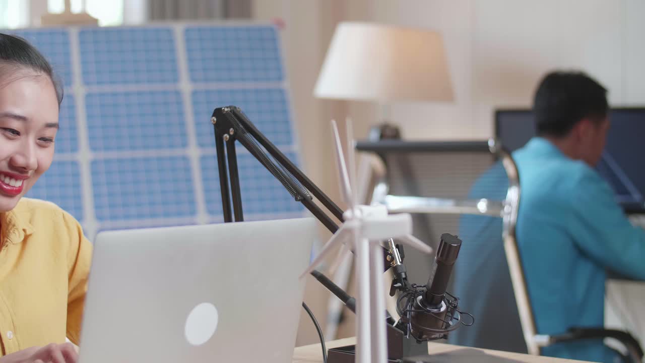 사무실에서 컴퓨터로 일하는 태양전지 패널을 가진 아시아 여성과 남자의 클로즈업