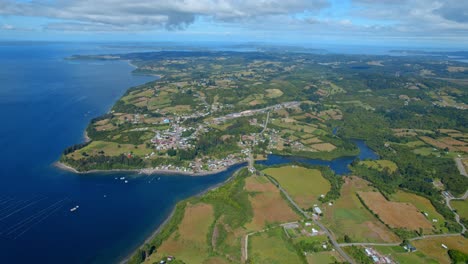 Lemuy-island-in-chiloe,-lush-greenery-and-coastline-under-blue-skies,-aerial-view