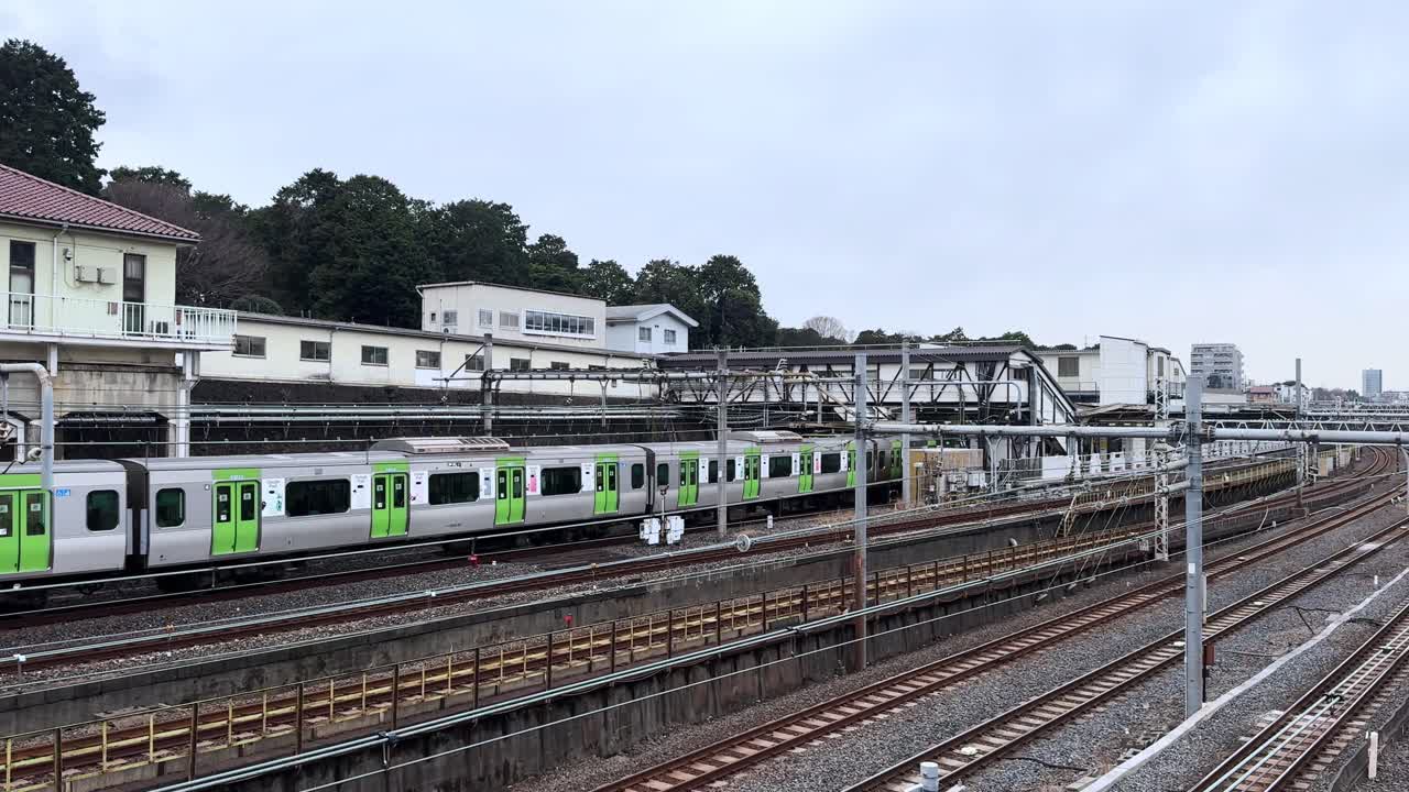 Train passing through the station in a peaceful urban setting with cloudy skies