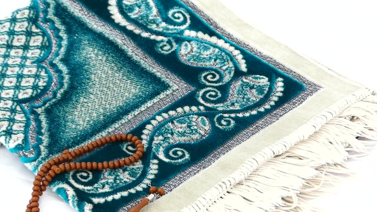 Primo piano di tappeto da preghiera e rosario, Islam e tappeto da preghiera, dove i musulmani pregano in prostrazione.