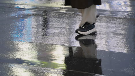 People-Crossing-A-Wet-Concrete-Road-During-Rainy-Evening-In-Tokyo,-Japan