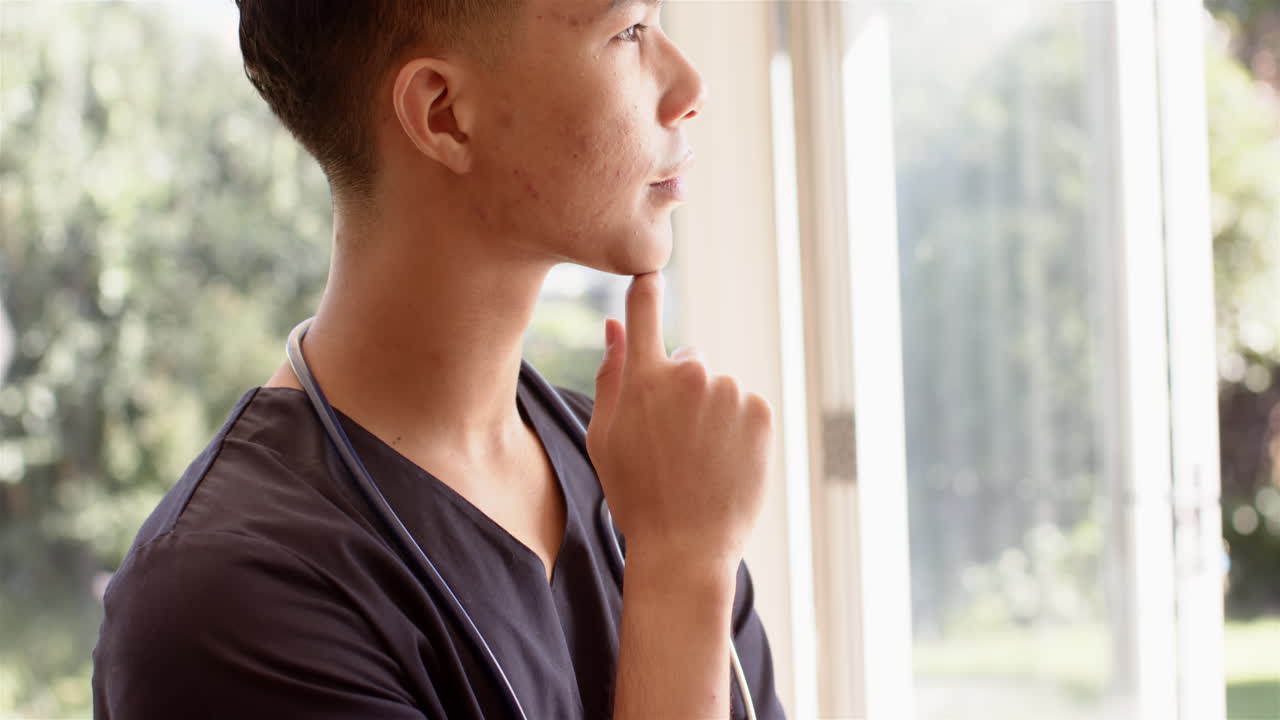 Meditating near window, male physiotherapist with stethoscope relaxing