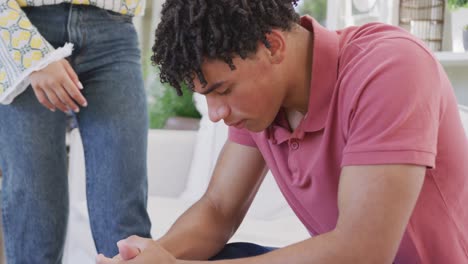 triste pareja biracial pasando el tiempo en casa juntos sentados en el sofá y animando