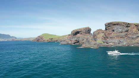 Barco-De-Lujo-Explorando-La-Costa-Salvaje-Del-Remoto-Ilhéu-Do-Farol-En-Un-Día-Soleado