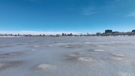 Paso-Bajo-Rápido-Sobre-El-Lago-Sloan-Para-Revelar-El-Paisaje-Urbano-De-Denver-En-La-Distancia-Durante-La-Tormenta-De-Invierno