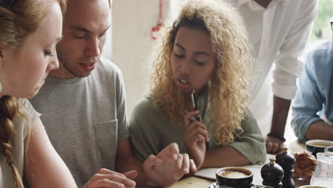 small business start-up meeting in cafe sharing touchscreen devices