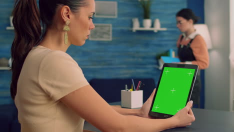 Freelancer-holding-tablet-computer-with-mock-up-green-screen-chroma-key-display