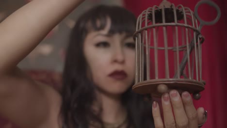 pretty lady holding metal cage with key inside of it