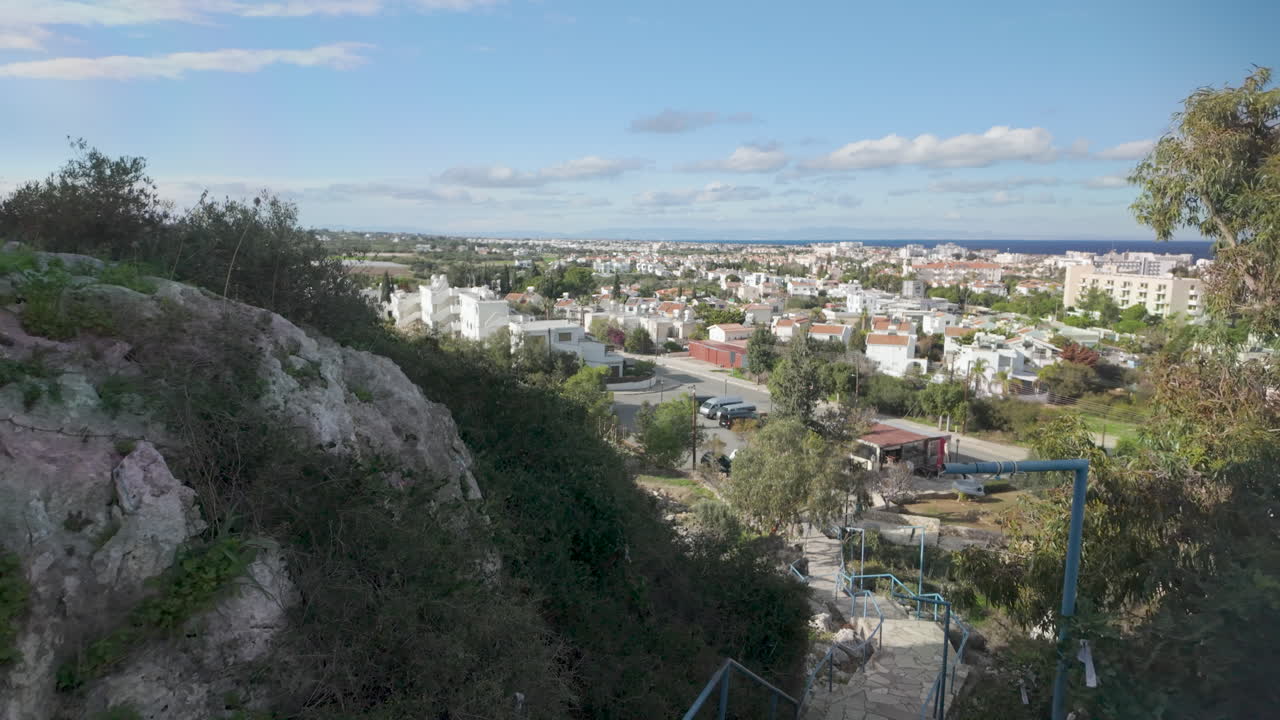 vista panorámica desde una ladera sobre la ciudad costera de protaras, chipre, con edificios residenciales extendidos hacia el horizonte bajo un cielo parcialmente nublado