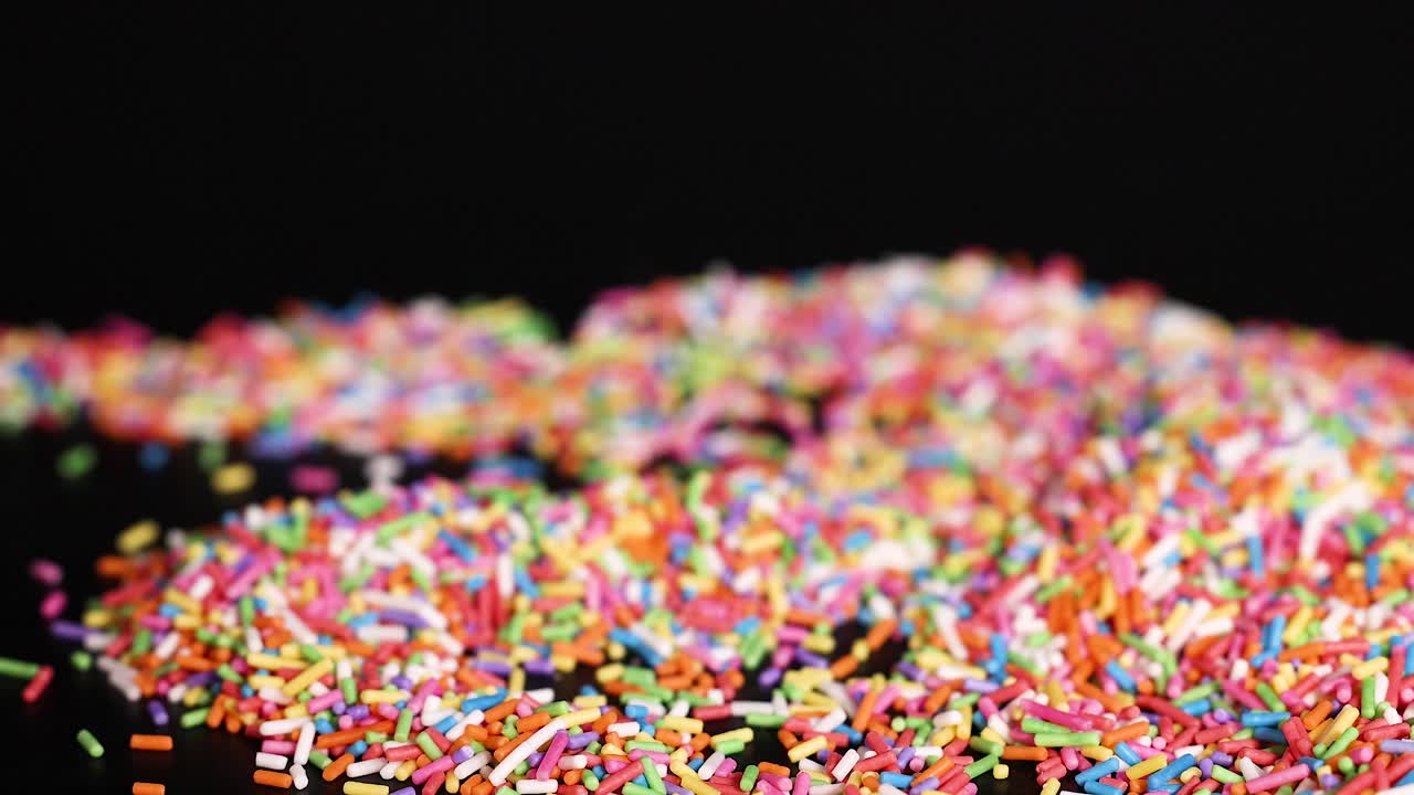 Hands interacting with colorful sprinkles on surface