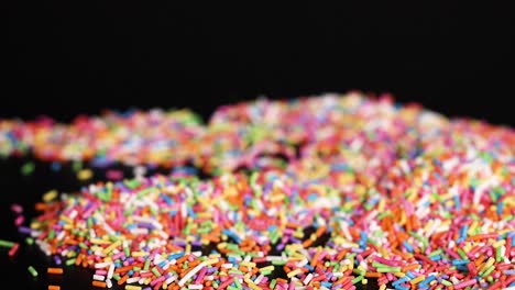 hands interacting with colorful sprinkles on surface