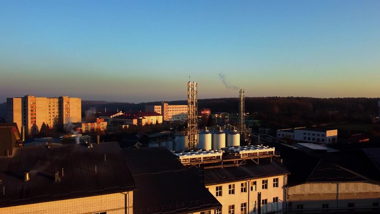 Widok z lotu ptaka drona lecącego nad browarem, kilka rzędów zbiorników